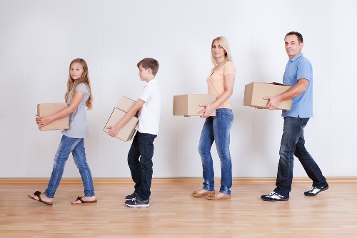 Professional movers carrying furniture through a residential property